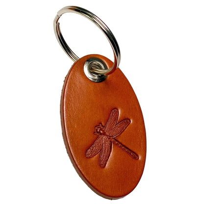 Brown leather keychain with embossed dragonfly design on a white background
