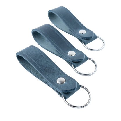 Three admiral blue leather keychains with metal rings on a white background