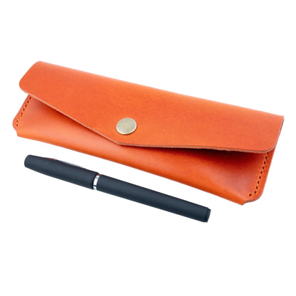 Orange leather pen case with a black pen on a white background